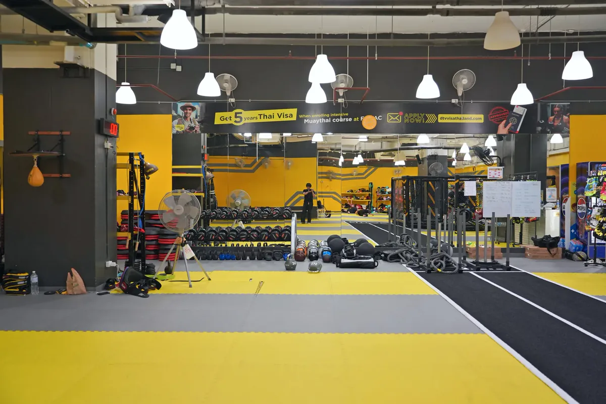 Gym dilihat dari ujung seberang, dengan lintasan sprint dan zona peralatan — FITFAC Rama 9