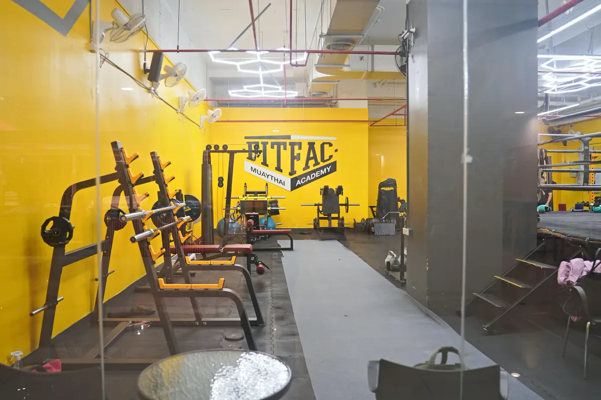 Squat rack dan barbel di ruang beban — FITFAC Rama 9