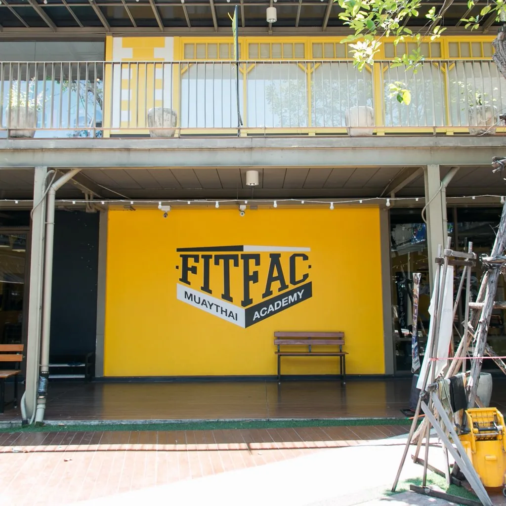 หน้ายิมแบบเปิดโล่ง ผนังโลโก้ FITFAC กับม้านั่ง — FITFAC สาขาราชพฤกษ์
